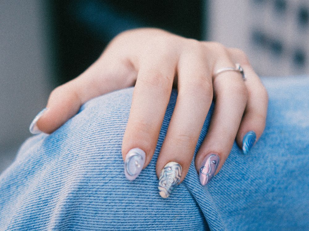 Nail art personalizado con diseño artístico nacarado en uñas almendra
